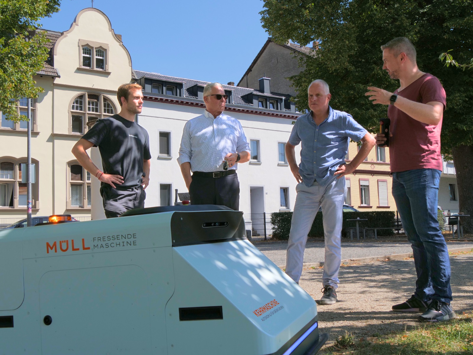Frank Schneider und Thomas Riehl (2.u.3.v.l.) sind überzeugt: Der Müllsauger-Roboter ist für die SBN eine sinnvolle Investition. (Foto: SBN/Maxie Meier)