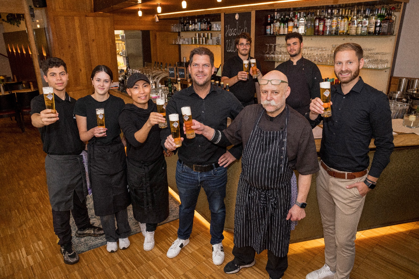 Auf eine erfolgreiche Zusammenarbeit - vorn, v.r.: Fabian Hsch, Jrg Wisser, Jens Geimer und das Team des D-Hauses. (Fotoquelle: Westerwald-Brauerei)