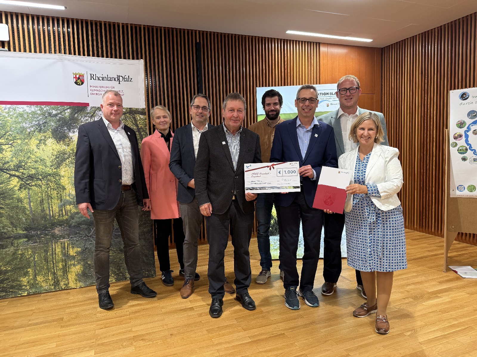 V.l.: Roger Best, Wasserbehrde Westerwaldkreis, Gabriele Wieland, Erste Kreisbeigeordnete Westerwaldkreis, Oliver Gtsch, Brgermeister VG Selters, Friedhelm Kurz, 2. Vorsitzender ARGE Saynbach, Michael Vogel, Wasserbehrde Kreis Neuwied, Axel Dietz, 1. Vorsitzender ARGE Saynbach, Philipp Rasbach, Erster Kreisbeigeordneter Neuwied, Katrin Eder, Ministerin fr Klimaschutz, Umwelt, Energie und Mobilitt. (Foto: MKUEM)