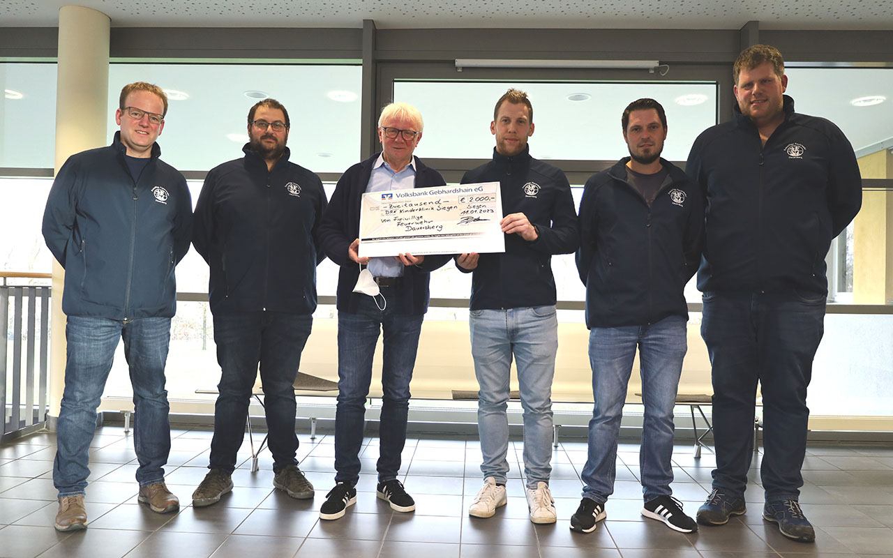 Chefarzt Dr. Heiner Ellebracht (3. Von links) nimmt die Spende der Freiwilligen Feuerwehr Dauersberg in den Rumen der KJP in Empfang. (Foto: DRK-Kinderklinik)