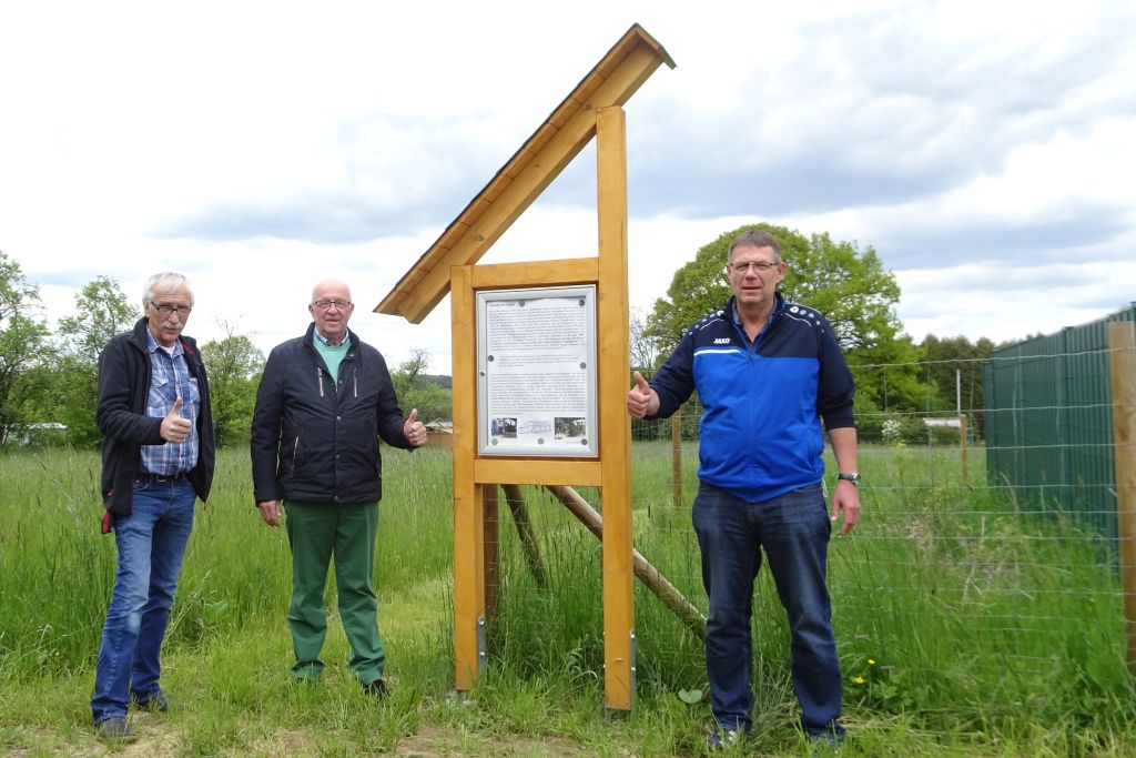 Brgermeister Uli Schneider, Gemeindehistoriker Bernd Schrupp und Bernd Menger, Klinikpatient aus dem Schreinerei-Arbeitstherapie prsentieren die frisch errichtete Erinnerungstafel. Foto: privat