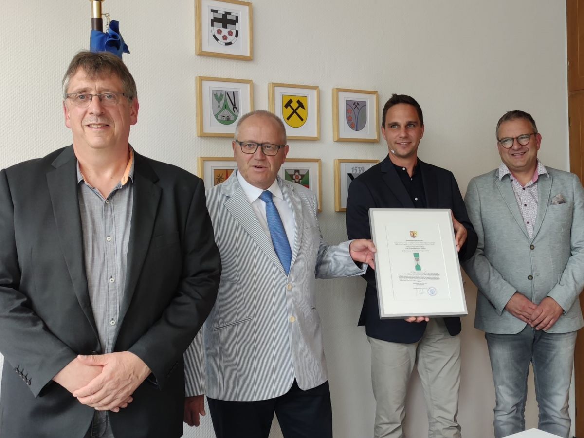 Landrat Dr. Peter Enders berreicht Ortsbrgermeister Matthias Grohs die Genehmigungsurkunde zum Fhren der Gemeindeflagge; links Ortsbeigeordneter Michael Gotto, rechts Brgermeister Berno Neuhoff. (Foto: Verwaltung)