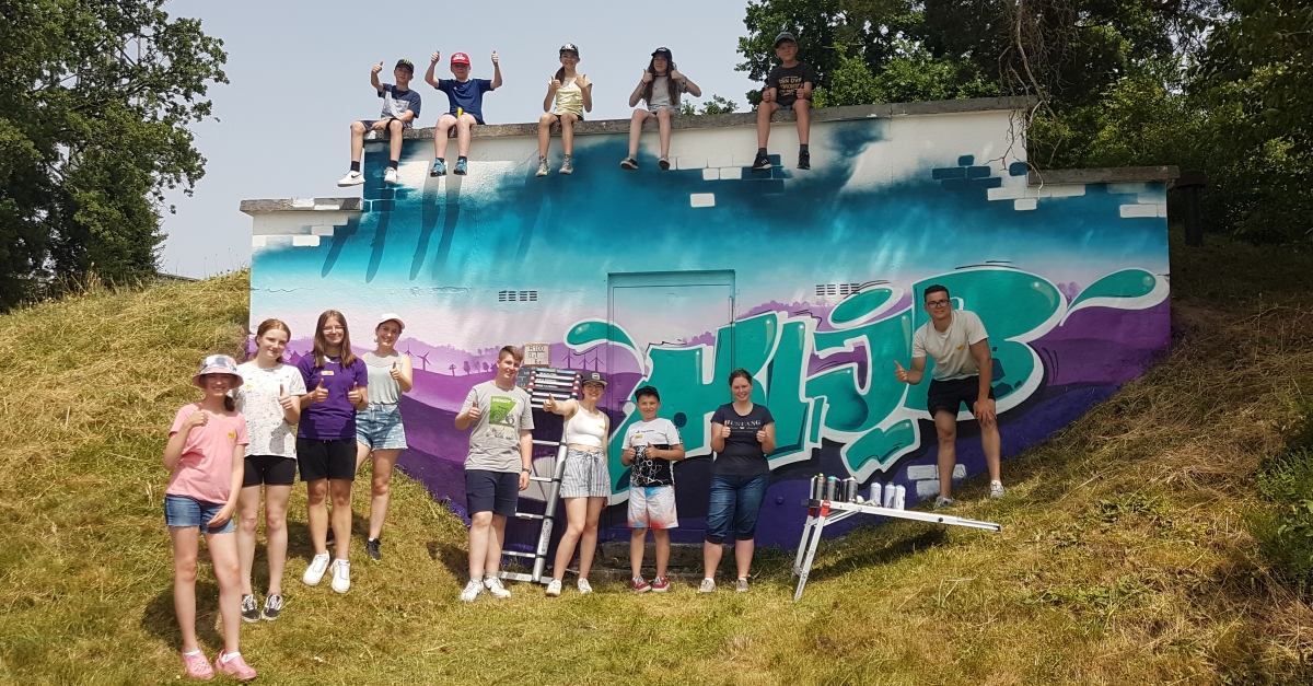 Die Jugendlichen präsentieren ihr Graffiti-Kunstwerk. (Foto: KLJB Friesenhagen)