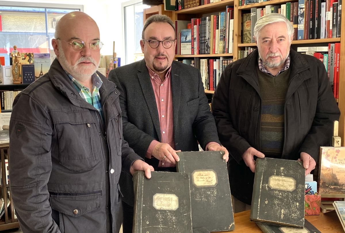 bergabe der Urkunden-Bnde an K. E. Schneider (links) und Roland Hille (rechts) durch den Antiquar Helmut R. Lang (Rennerod). Foto: privat