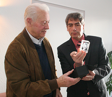 Horst Moog (links) erhielt von Bürgermeister Dietmar Henrich als Dank den Raiffeisenkopf in Glas. Foto: Verwaltung