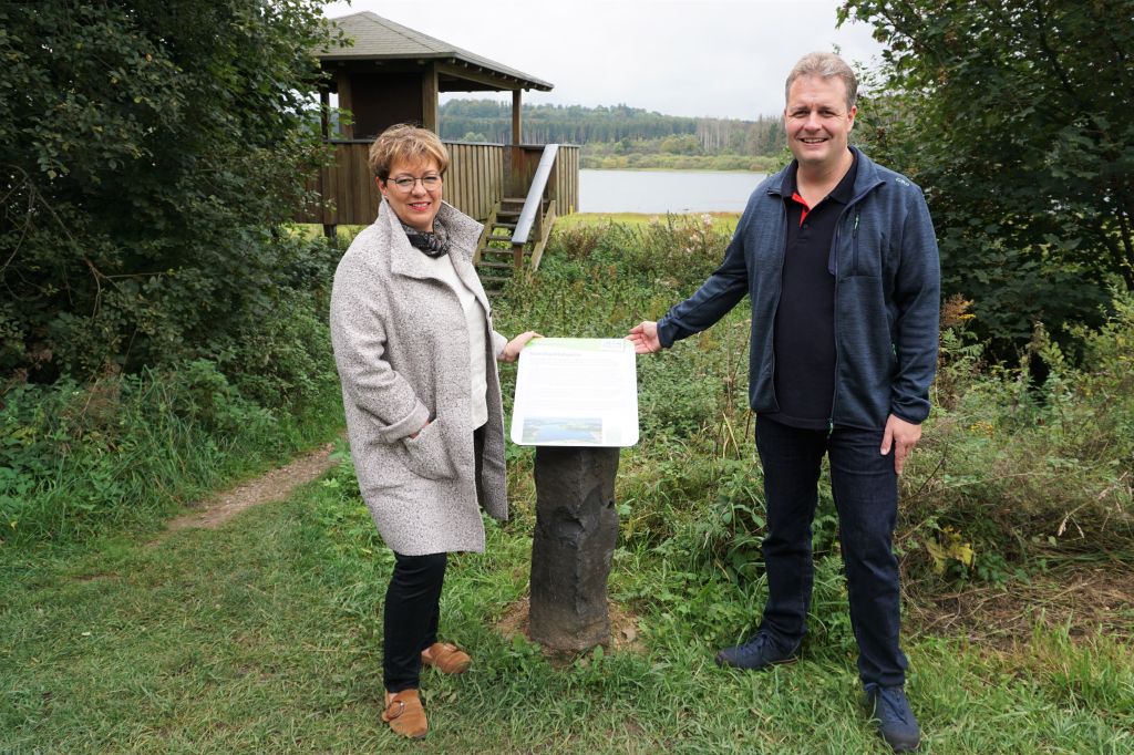 Petra Schneider (Vorsitzende Verkehrsverein Hoher Westerwald e.V.) und Brgermeister Gerrit Mller prsentieren die Infosule an dem NABU-Aussichtsstand an der Krombachtalsperre. Foto: Kerstin Guckert