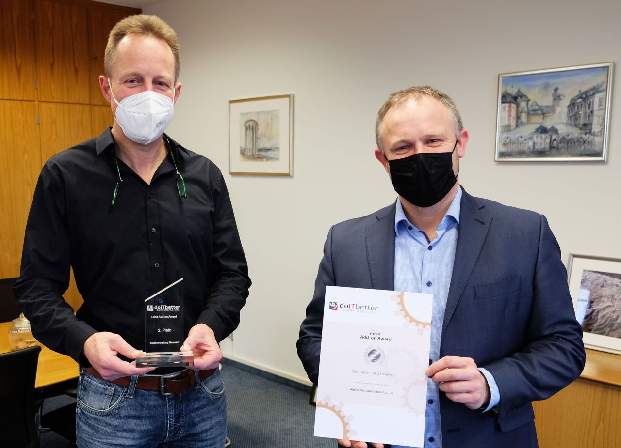 Neuwieds Oberbrgermeister Jan Einig (rechts) freut sich ber die Leistungsfhigkeit des IT-Amts. Dessen Leiter Gerhard Wingender prsentiert den Pokal, den sein Team fr den zweiten Wettbewerbsplatz erhielt. Foto: Stadt Neuwied