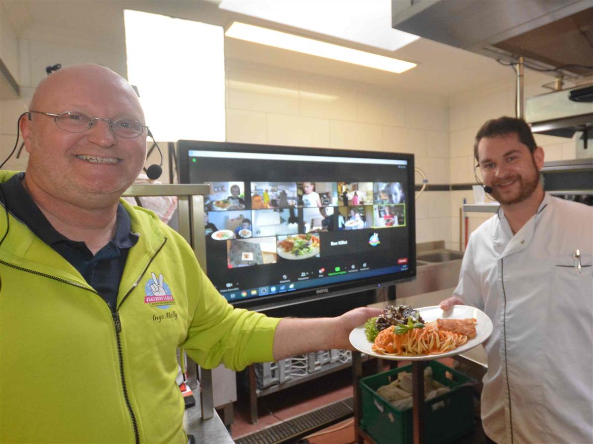 Das sieht lecker aus: Ingo Molly (links) und Christian Haas halten einen angerichteten Teller, wie auch die Kinder im Hintergrund auf dem Monitor. (Fotos: tt)