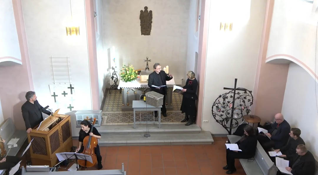 Dr. Harald Leyser (Mitte) als Hans Karbe und Felizitas Muntanjohl (rechts) als Hildegard Klepper. Am linken Bildrand Mitwirkende des Kammerorchesters unter der Leitung von Martin Buschmann (stehend), am rechten Bildrand die Mitwirkenden des Kammerchors. Foto: Sabine Hammann-Gonschorek