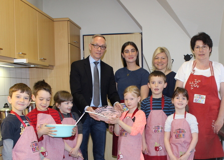 Volker Stausberg (Barmer) hat Damla Baysal, Brita Comisel und Marion Smolny (v.l.n.r., alle Kita Alte Bahnhofsschule) und die Kita-Kinder bei einer Kochaktion besucht. (Foto: Kita Alte Bahnhofsschule)