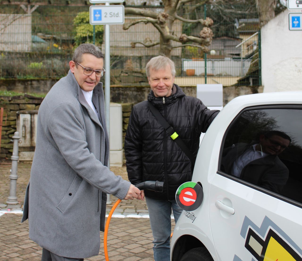 V. links: Kersten Kerl (Vorstand BHAG) und Otto Neuhoff (Brgermeister Bad Honnef) an der neuen Ladestation am Ziepchensplatz in Rhndorf. Foto: BHAG