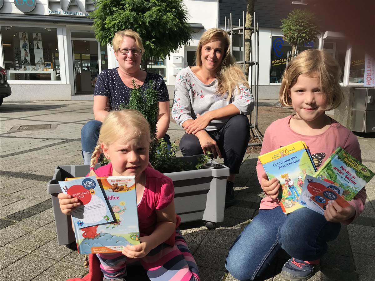 Lesesommerkinder Luisa und Johanna nutzen die letzte Ferienwoche, um Stempel fr die Lesesommer-Clubkarte zu sammeln Johanna hat bereits 20 Bcher gelesen, ihre Schwester Luisa, mit gerade mal fnf Jahren das jngste Lesesommer-Kind in diesem Jahr, schon 17 Bcher. Daher kommt auch  bald fr beide die Einladung zur Lesesommer-Abschlussparty. Ute Merker und Yvonne Heuer von der Bcherei freuen sich ber die vielen lesebegeisterten Betzdorfer Kinder. (Foto: kumenische Stadtbcherei Betzdorf)