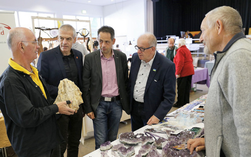 Vereinsvorsitzender Manfred Flinzner (links) gab Ehrengsten und  Besuchern der 27. Westerwlder Mineralienbrse in Horhausen einen kleinen Einblick in die Welt der Steine. (Foto: Verbandsgemeinde Flammersfeld) 