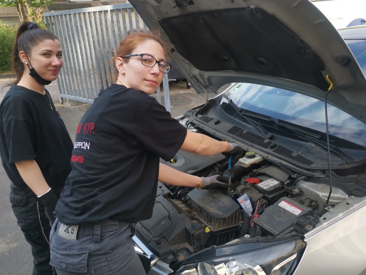 In einem Rollenspiel zeigt KFZ-Mechatronikerin Paschalina Manoli Mpezou ihrer Auszubildenden, wie ein Luftfilter ausgetauscht wird. (Foto: Handwerkskammer)