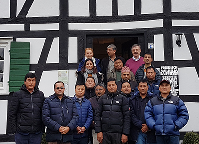 Sonja Hauertmann und Josef Zolk mit der Besuchergruppe aus Nepal vor dem Flammersfelder Raiffeisenhaus. Foto: GIZ