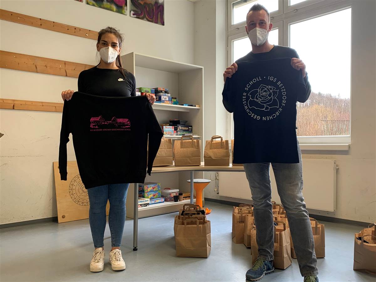 Die Vertrauenslehrer Julia Schneider und Marius Kraft prsentieren die neue Schulbekleidung. (Foto: Schule) 