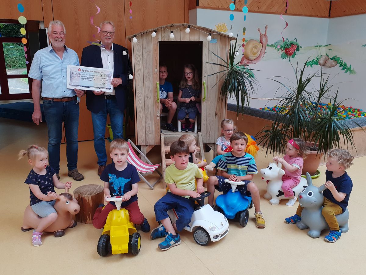 Dank einer Spende wurde die Anschaffung eines Kinderspielhauses Bauwagen mglich. Links hinten ist Brgermeister Giehl zu sehen, der von Joachim Lorsbach, Prokurist der Firma HB-Protectif Wear, den symbolischen Spendencheck annimmt. (Foto: Ortsgemeinde Gebhardshain) 