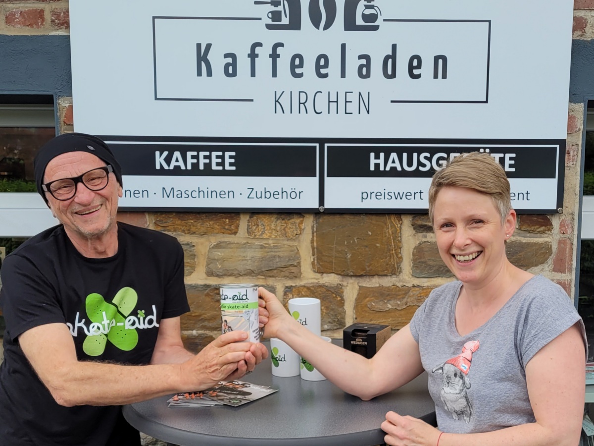 Spendenbergabe vorm Geburtshaus, in dem sich mittlerweile ein Kaffee-Fachgeschft befindet (von links): Titus Dittmann und die Betreiberin des "Kaffeeladens Kirchen", Tabea Bacher. (Foto: "Kaffeeladen Kirchen") 
 