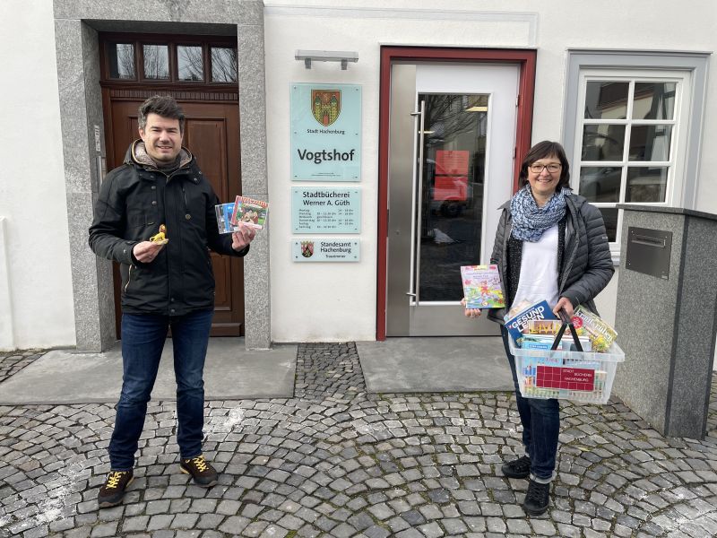 Stadtbrgermeister Stefan Leukel und Bchereileiterin Delya Gorges weisen darauf hin, dass die Stadtbcherei Werner A. Gth in Hachenburg whrend des Lockdowns einen kontaktlosen Abholdienst fr Medien anbietet. Foto: Stadt Hachenburg