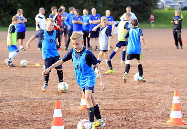 Whrend die Kids die bungen absolvieren erklrt Manfred Rehbein, als einer der Mentoren vom DFB-Mobil, im Hintergrund den Trainern worauf es beim Kinder- und Jugendtraining ankommt. Foto: Niebergall
