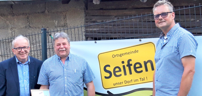 Verbandsgemeinde-Beigeordneter Rolf Schmidt-Markoski (links) ehrte den scheidenden Seifener Ortsbrgermeister Martin Weingarten (Mitte) fr sein 25-jhriges Engagement im Gemeinsinn. Sein Nachfolger Torsten Walterschen dankte ihm ebenfalls fr sein Wirken. (Foto: Ortsgemeinde Seifen)