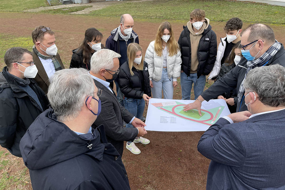 Von links unten im Uhrzeigersinn: Tim Dunker (Schulelternbeirat), Marco David (Fachvorsitz Sport), Landrat Achim Hallerbach, Schulleiter Michael Strauss, Sportlehrerin Jennifer Zunkel, Verbindungslehrer Jrg Eckert Zunkel (Sport), die Schlervertreter Johanna Welle (mit der Hand am Plan), Carlotta Burger, Moritz Huxoll, Fabian Fogel und Sophie Hartstang, sowie Rdiger David und Beigeordneter Michael Mahlert. Foto: Kreisverwaltung.